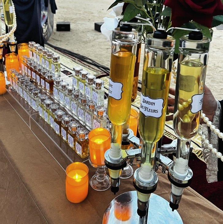 Candlelit perfume bar table with amber dispensers Event perfume bar table with amber and yellow dispensers, small vials and glowing candles